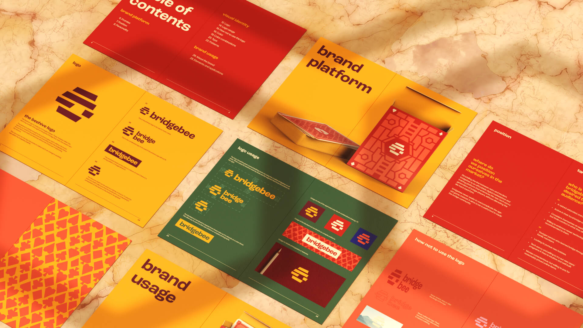 A flat lay of colorful brand guideline booklets and cards arranged on a marble surface, featuring red, yellow, and green themes, with text like brand platform, brand usage, and various logo designs.