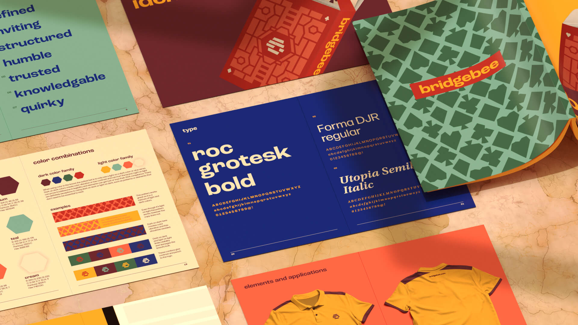 A flat lay of colorful branding materials, including booklets, brochures, and clothing mockups, featuring bold typography, geometric patterns, and brand colors on a marble surface.
