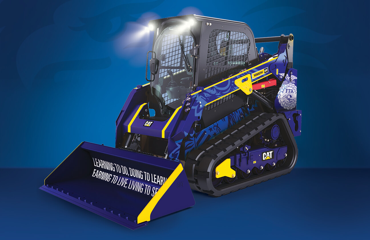 A blue and yellow Caterpillar track loader with police and FFA-themed graphics is displayed on a blue gradient background. The loader’s headlights are on, and the bucket features motivational text.