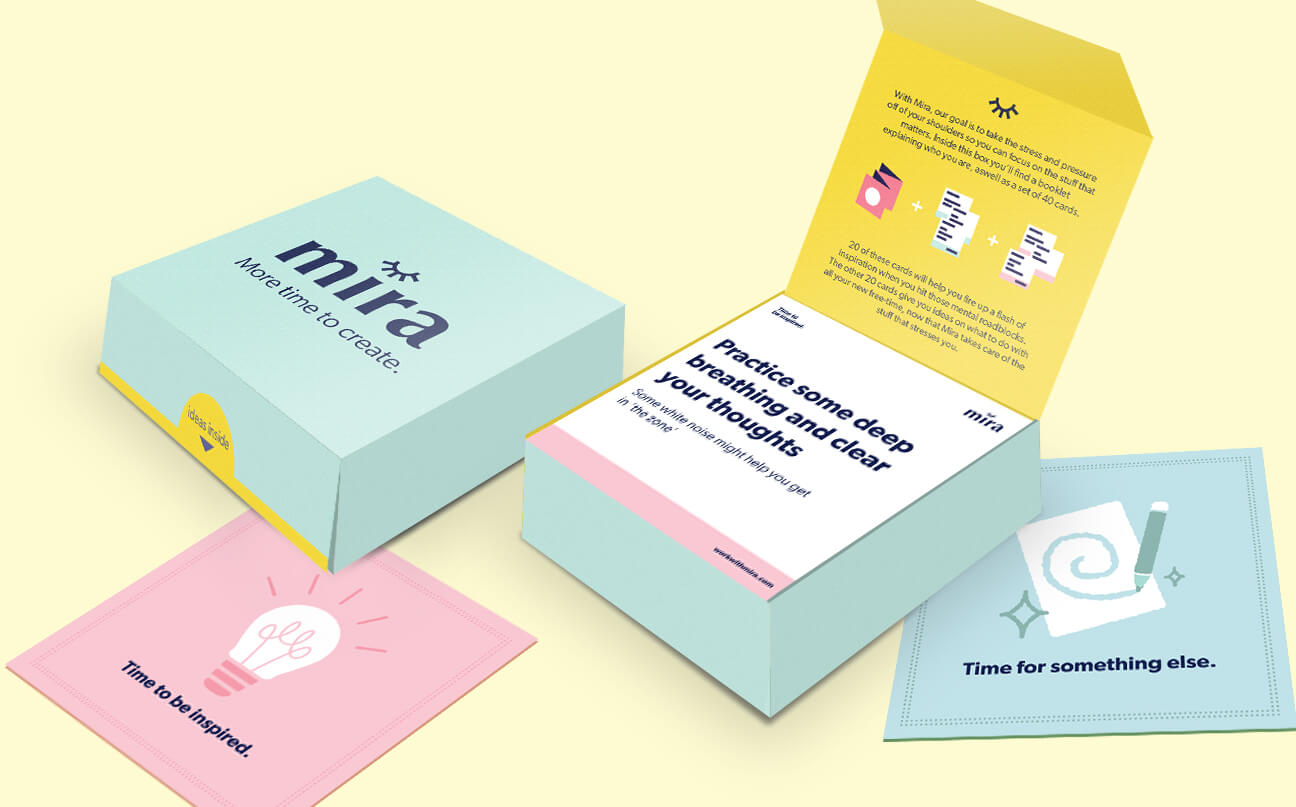 Two pastel-colored boxes are shown, one closed and one open. The open box reveals instruction cards inside, with the visible card reading, “Practice some deep breathing and clear your thoughts.” Other cards are spread around.