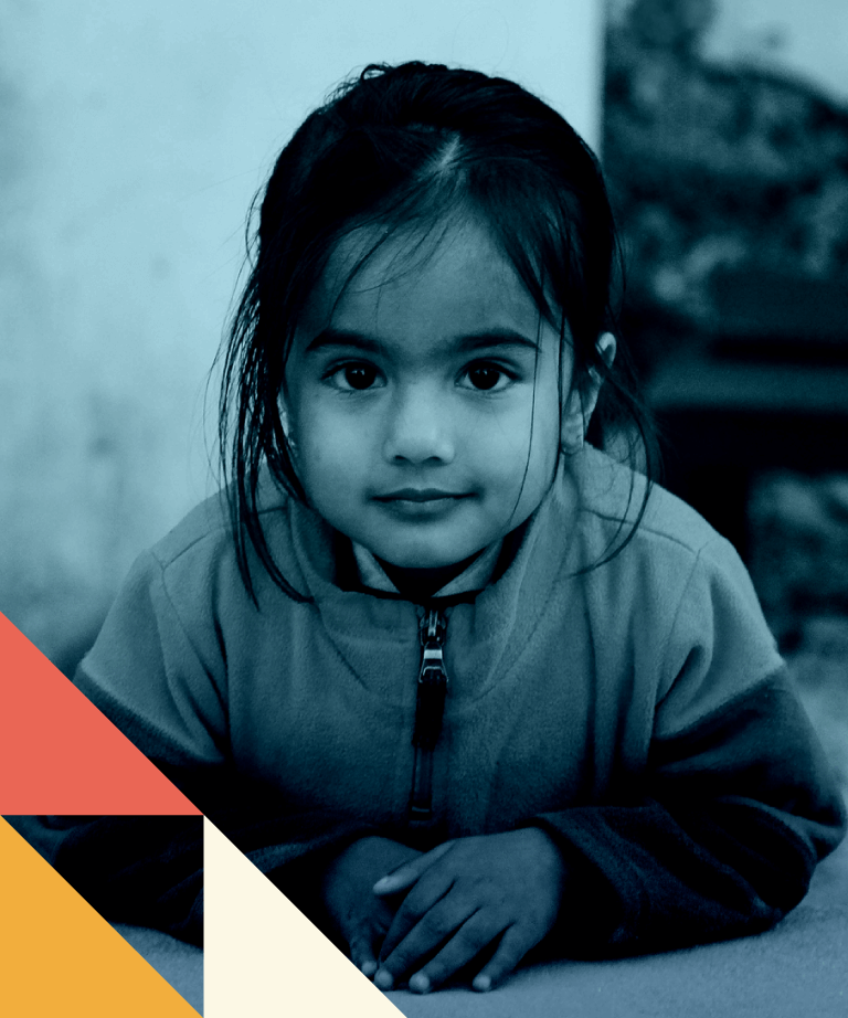 A young girl with dark hair and a calm expression leans forward on her arms, wearing a zip-up jacket. Geometric shapes in red, yellow, and cream decorate the bottom left corner of the image.