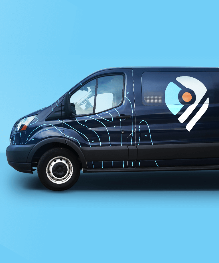 A dark blue van with a modern abstract design and a white, blue, and orange logo on the side, parked against a solid light blue background.