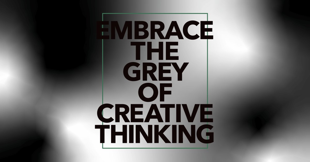 Bold black text saying Embrace the grey of creative thinking is centered on a blurred grey and white gradient background. The text is surrounded by a thin, green rectangular outline.