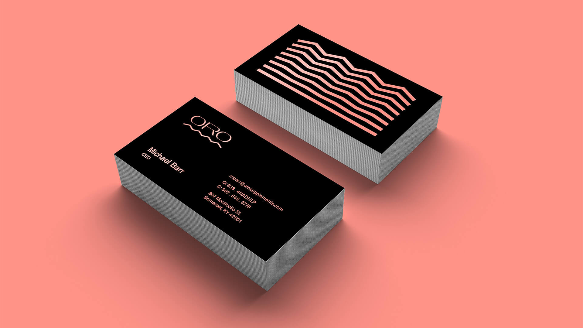 Two stacks of modern black business cards on a coral background. One card shows abstract coral lines, while the other displays contact info and a minimalist logo reading ORO in white and coral text.