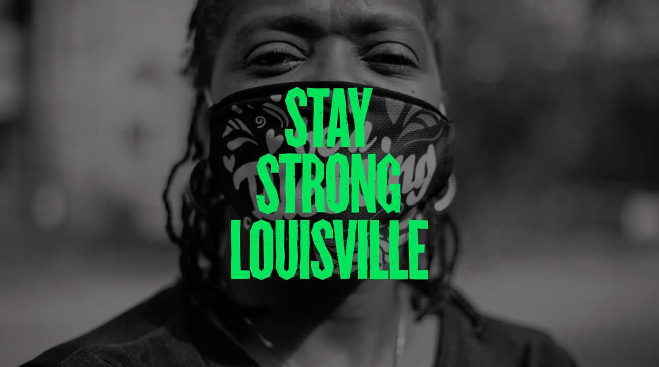 A person wearing a patterned face mask stands outdoors. Green bold text over the image reads, STAY STRONG LOUISVILLE.
