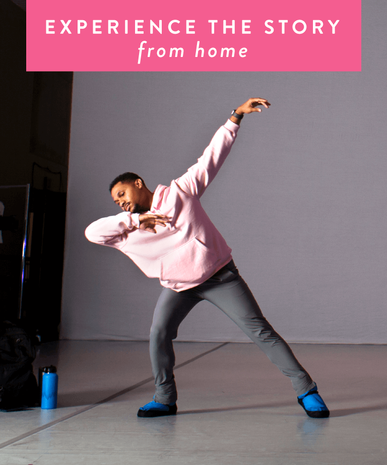 A person in a pink hoodie and blue shoes dances in a studio. A blue water bottle sits on the floor. Text at the top reads, EXPERIENCE THE STORY from home.