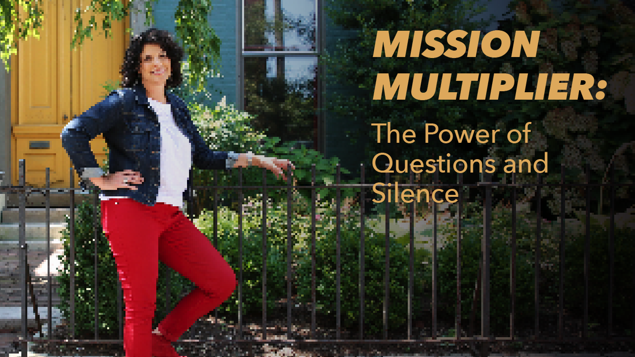 A woman in red pants and a denim jacket stands by a black iron fence. Text reads: Mission Multiplier: The Power of Questions and Silence. A yellow door and greenery are in the background.
