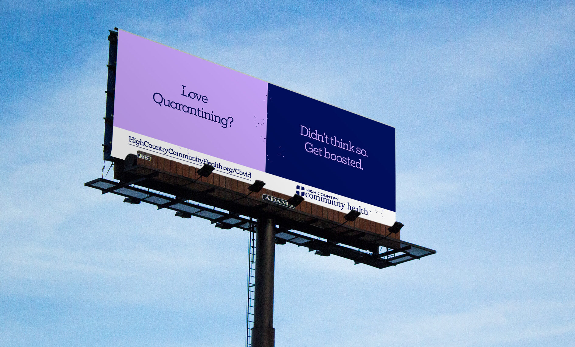 A billboard against a blue sky reads: Love quarantining? Didnt think so. Get boosted. in purple and dark blue panels, promoting COVID-19 booster shots from High Country Community Health.