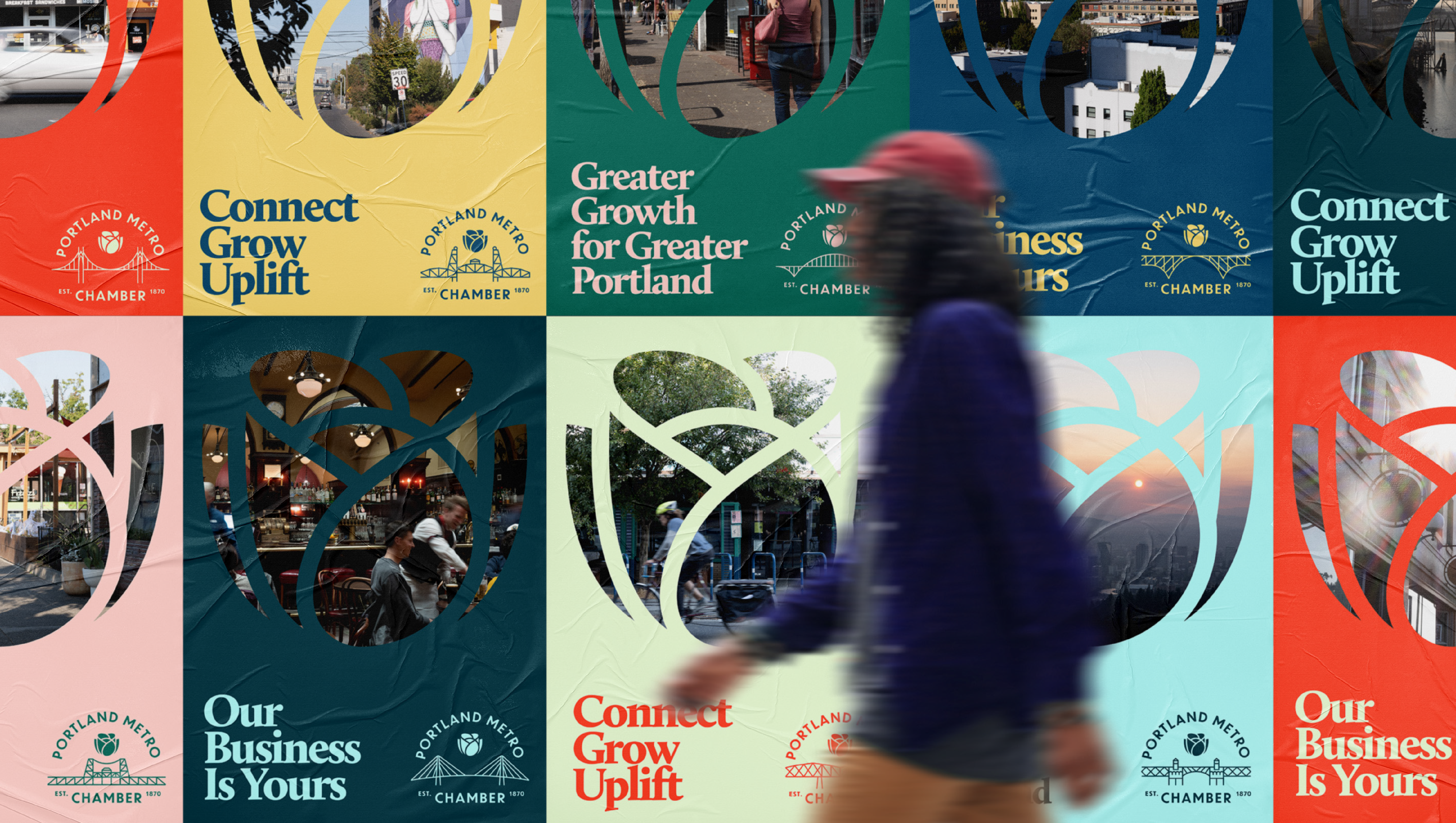 A person in a red cap walks past a colorful mural of posters promoting the Portland Metro Chamber, with phrases like “Connect Grow Uplift,” “Greater Growth for Greater Portland,” and “Our Business Is Yours.”.