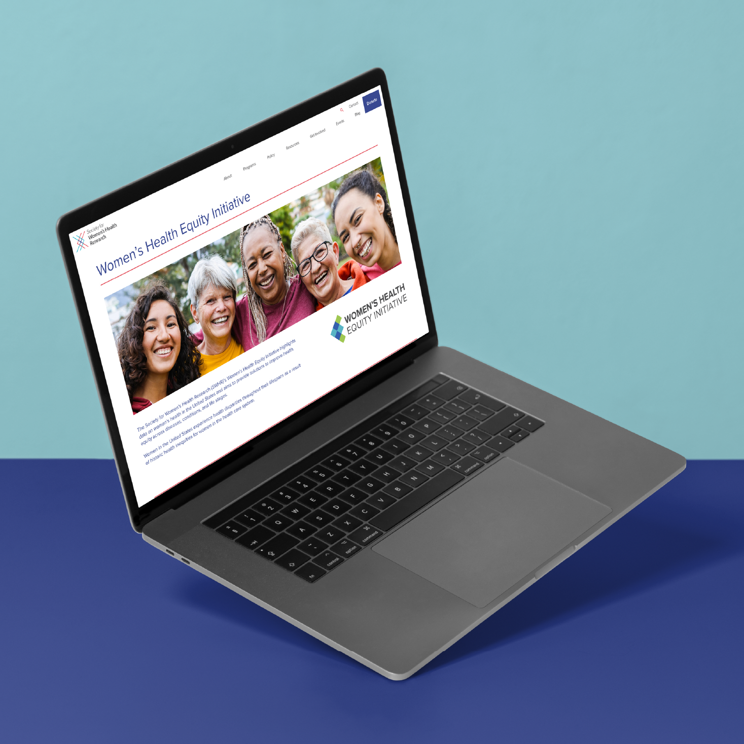 A laptop on a blue surface displays a website for the Women’s Health Equity Initiative, featuring a banner image of five diverse women smiling together outdoors.